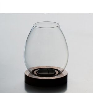 Clear egg-shaped glass tealight lantern on a round dark wooden base with a tealight in the recess