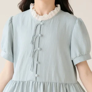A young girl wearing an elegant summer dress with a lace collar, standing in the sun during a picnic.