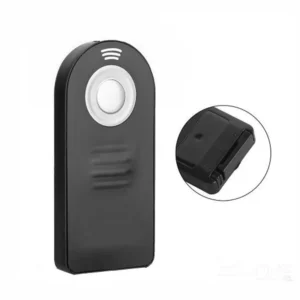 Wireless remote shutter release held in hand next to Nikon DSLR camera